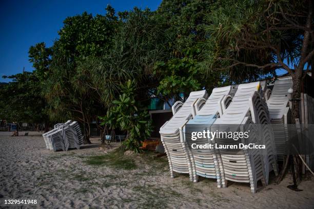 Unused chairs are stacked in front of resorts on Patong Beach, once Phuket's most popular tourist beach, on July 19, 2021 in Phuket, Thailand....