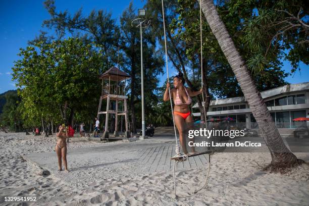 Local Thai's pose for photos on Patong Beach on July 19, 2021 in Phuket, Thailand. Travelers visit popular beaches in Phuket, Thailand as part of a...