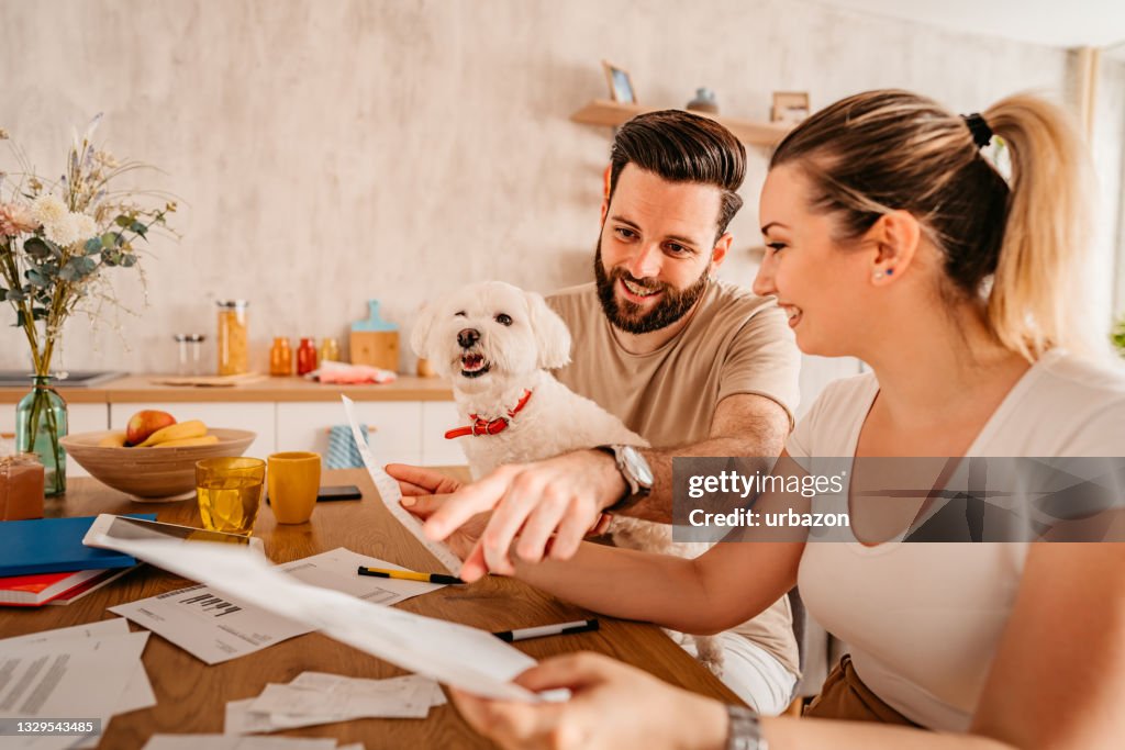 Coppia che controlla le loro finanze a casa con il loro cane