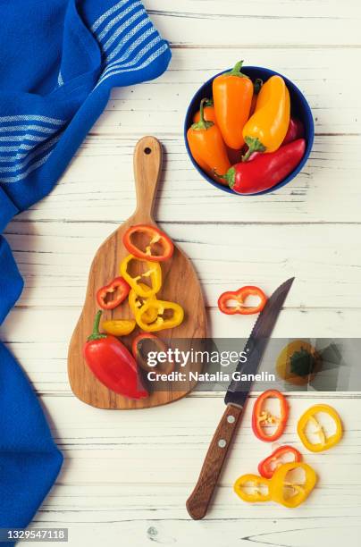 sweet bell peppers and cutting board - orange bell pepper fotografías e imágenes de stock