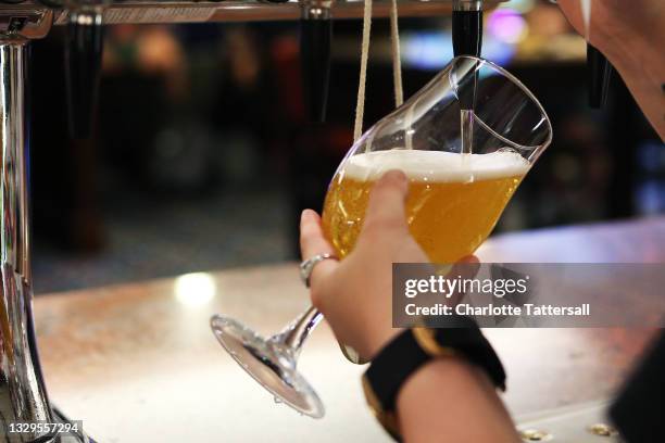 Member of staff pours a pint for a customer at Wetherspoons pub The Moon Under Water on July 19, 2021 in Manchester, England. As of 12:01 on Monday,...