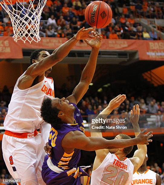 Fab Melo and Brandon Triche of the Syracuse Orange reach for the rebound against Gerardo Suero of the Albany Great Danes during the NIT Season...