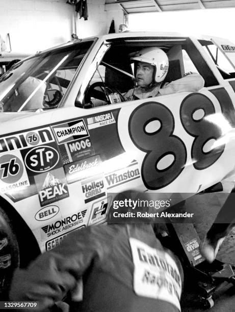 Driver Bobby Allison sits in his race car in the speedway garage during a practice session prior to the running of the 1982 Daytona 500 race at...