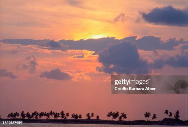 View of a sunrise, partially obscured by clouds, over an unspecified island, Bimini, Bahamas, August 2, 1998.