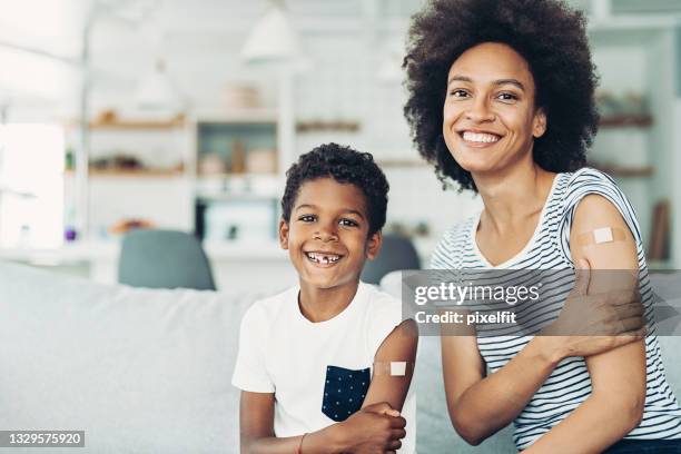 smiling mother and son got vaccinated - african american band aids stock pictures, royalty-free photos & images