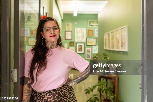 tattooed woman standing in the doorway of her tattoo studio - leopard print stock pictures, royalty-free photos & images