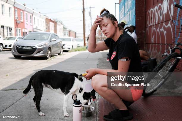 Rachael, who is struggling with heroin addiction, walks her dog Peanut in Kensington on July 19, 2021 in Philadelphia, Pennsylvania. According to...