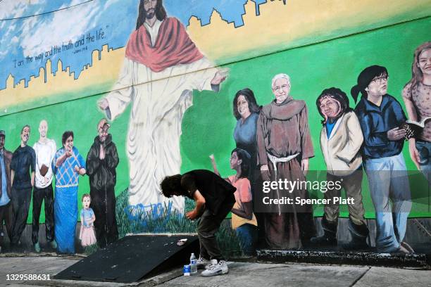 Man pauses under a mural in the Kensington neighborhood which has become one of the largest open-air heroin markets in the United States on July 19,...