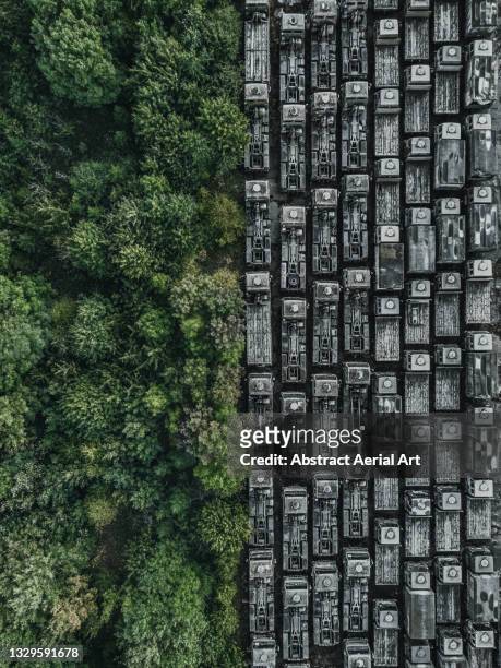 drone shot showing rows of abandoned trucks at the edge of a forest, england, united kingdom - drone images stock-fotos und bilder