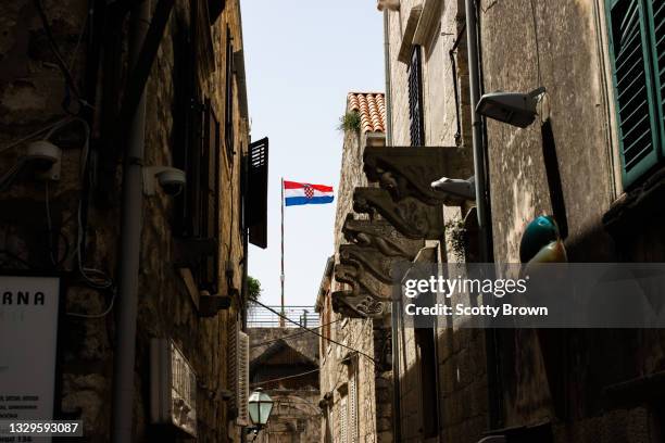 the croatian flag above korčula town, croatia - croatia flag stockfoto's en -beelden