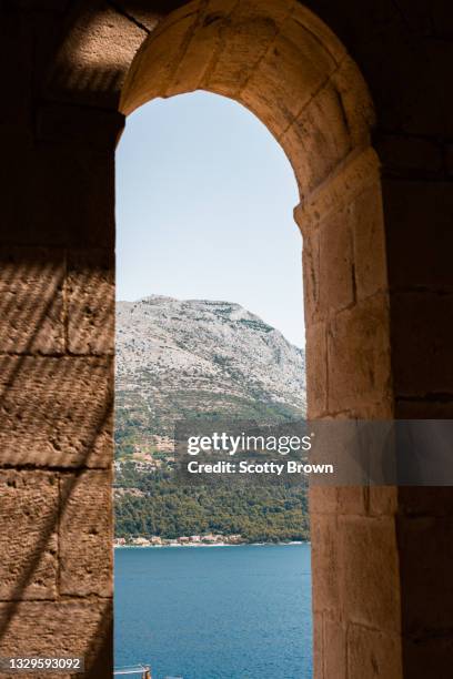 mountain and adriatic sea through cathedral tower window - korcula island stock pictures, royalty-free photos & images