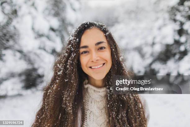 young pretty happy girl enjoying winter and beautiful snowy nature. portrait close-up - face snow stockfoto's en -beelden