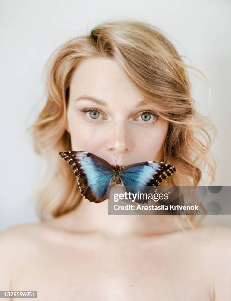 portrait of young woman with a big blue butterfly on her lips - animals with big lips stockfoto's en -beelden