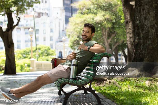 young man drinking mate at buenos aires square - mate argentina stock pictures, royalty-free photos & images