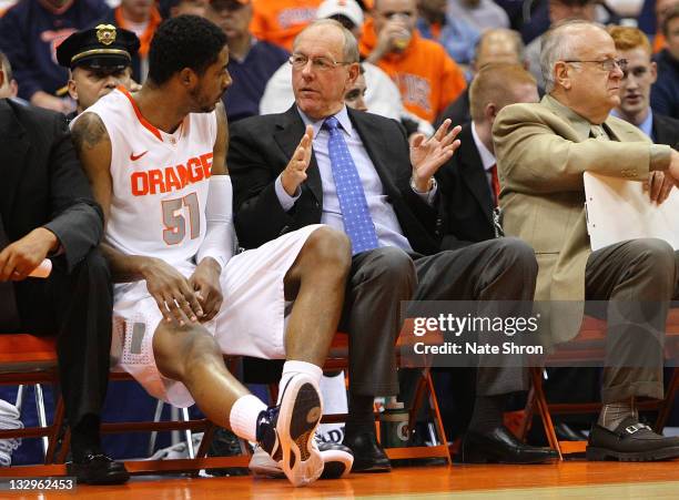 Jim Boeheim, head coach of the Syracuse Orange talks with player Fab Melo on the bench during the game vs the Albany Great Danes during the NIT...