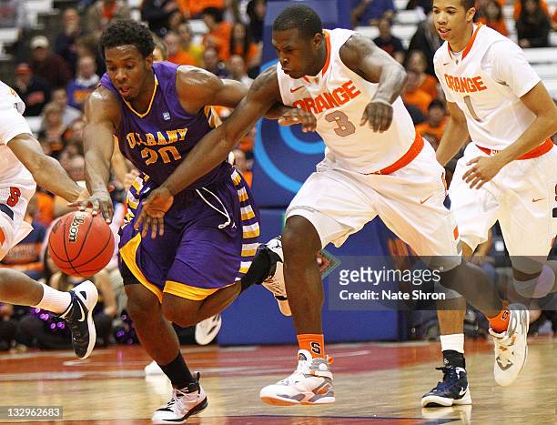 Dion Waiters of the Syracuse Orange chases down the ball with Gerardo Suero of the Albany Great Danes during the NIT Season Tip-off game at the...