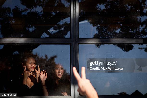 High school students wave to University of California, Berkeley students as they march through Berkeley as part of an "open university" strike in...