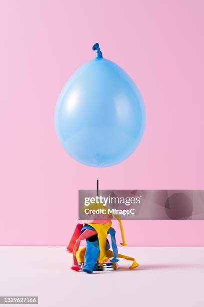 blue balloon about to fall on a spike - doorn stockfoto's en -beelden