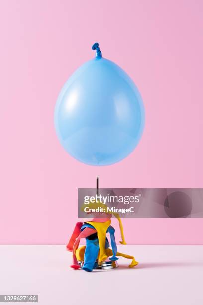 blue balloon about to fall on a spike - spiked imagens e fotografias de stock