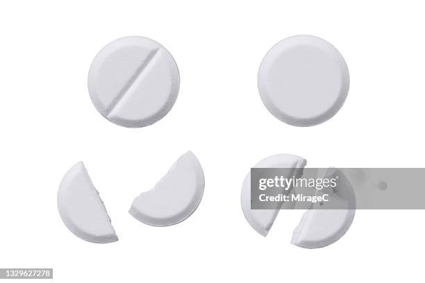 whole and halved white pills isolated on white - comprimés photos et images de collection