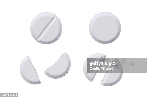 whole and halved white pills isolated on white - 錠剤 ストックフォトと画像