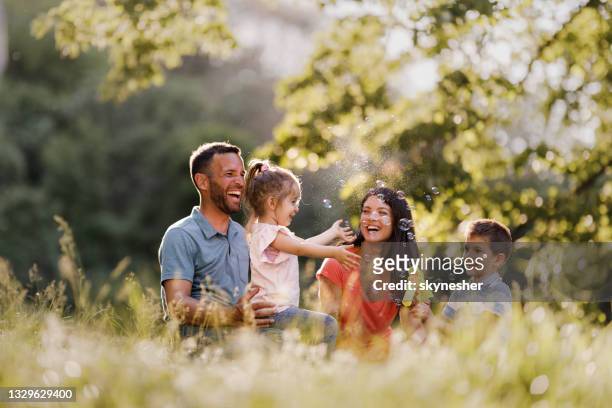 happy family having fun in spring day at the park. - bubbles happy stockfoto's en -beelden