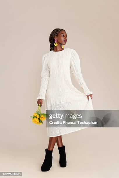 beautiful woman holding sunflowers - traje color crema fotografías e imágenes de stock