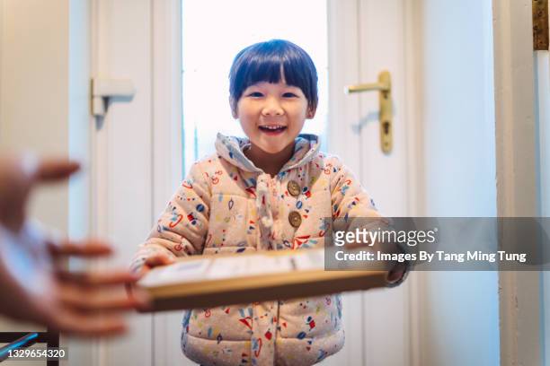 first person perspective of mom receiving a parcel passing from her daughter at home - receiving delivery stock pictures, royalty-free photos & images