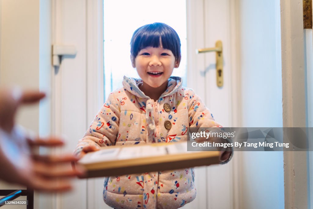 First person perspective of mom receiving a parcel passing from her daughter at home
