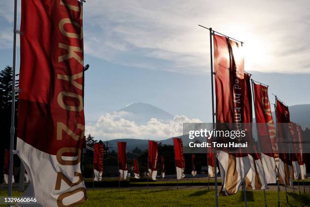 Japan's highest peak Mount Fuji is seen behind Tokyo 2020 flags at the Fuji International Speedway ahead of the Tokyo 2020 Olympic Games on July 20,...