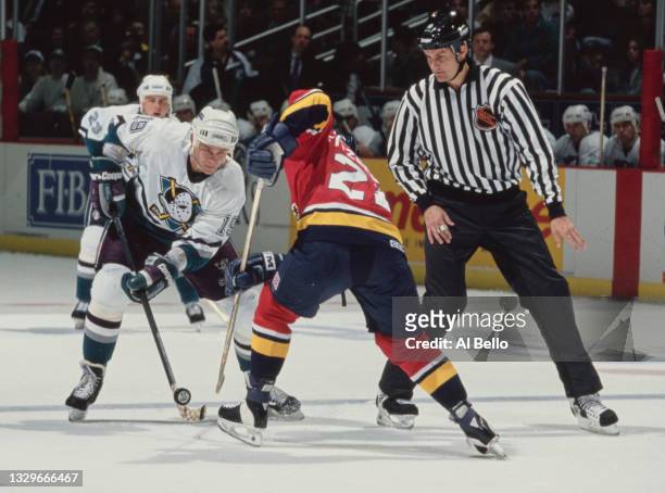 The referee looks on as Anatoli Semenov, Center for the Mighty Ducks of Anaheim and Tom Fitzgerald of the Florida Panthers face off during their NHL...