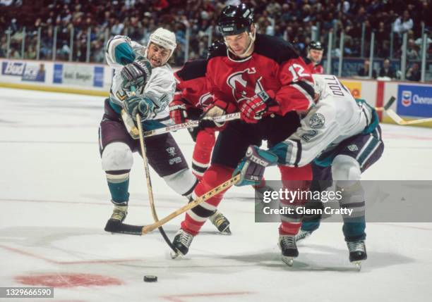 Bill Guerin, Right Wing for the New Jersey Devils fends off the check by Bobby Dollas and Kevin Todd of the Mighty Ducks of Anaheim during their NHL...