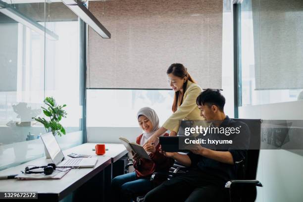 asiatische geschäftsleute, die im büro arbeiten - malay hijab stock-fotos und bilder