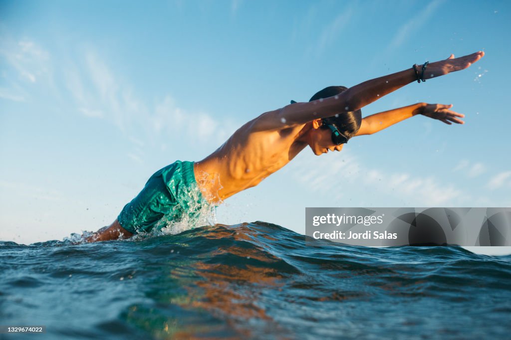 Boy jumping over the water's