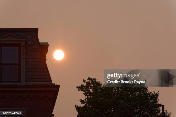 smoke from distant wildfires turns the boston sunrise red and hazy - smog stock pictures, royalty-free photos & images