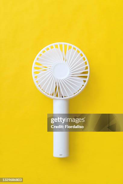 white plastic hand fan on a yellow background - electric fan ストックフォトと画像