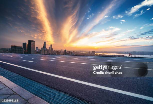 highway with the city skyline as the background at sunset - dusk street stock pictures, royalty-free photos & images