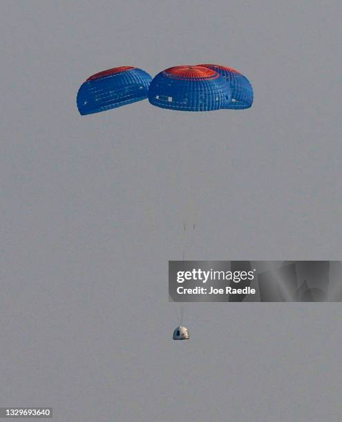 Blue Origin’s New Shepard crew capsule descends on the end of its parachute system carrying Jeff Bezos along with his brother Mark Bezos, 18-year-old...