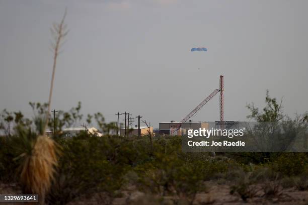 Blue Origin’s New Shepard crew capsule descends on the end of its parachute system carrying Jeff Bezos along with his brother Mark Bezos, 18-year-old...