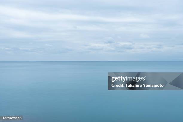 cloudy sky over the ocean - overcast ocean stock pictures, royalty-free photos & images