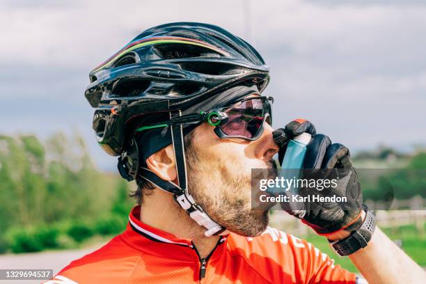 a cyclist using an asthma inhaler on a sunny day - stock photo - childhood asthma stock pictures, royalty-free photos & images