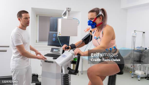 female athlete performing ecg and vo2 test on indoor bicycle - cardio stock pictures, royalty-free photos & images