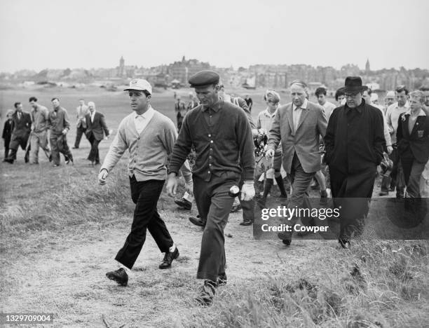 Gary Player of South Africa and Arnold Palmer of the United States are followed on the course by a crowd of spectators during a $10,000 television...