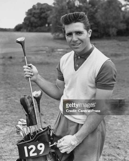 Gary Player of South Africa pulls a driver club from the golf bag as he poses for a photograph before the start of the 1956 Canada Cup 72-hole stroke...