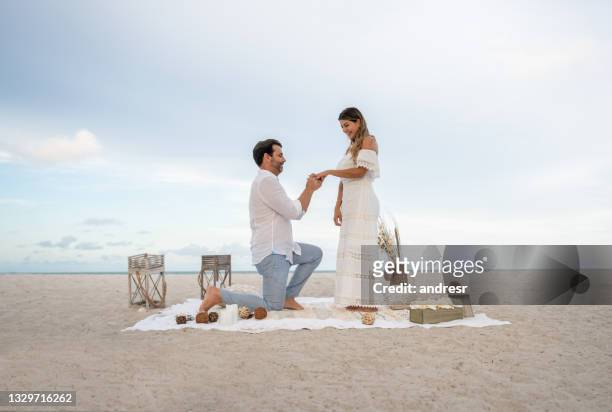 pareja amorosa que se compromete en un picnic romántico en la playa - prometido relación humana fotografías e imágenes de stock