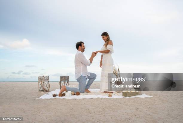 casal amoroso ficando noivo em um piquenique romântico na praia - noivado - fotografias e filmes do acervo