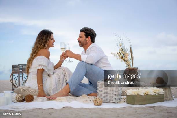 ビーチでロマンチックなデートで愛するカップルが乾杯 - intimate dinner ストックフォトと画像