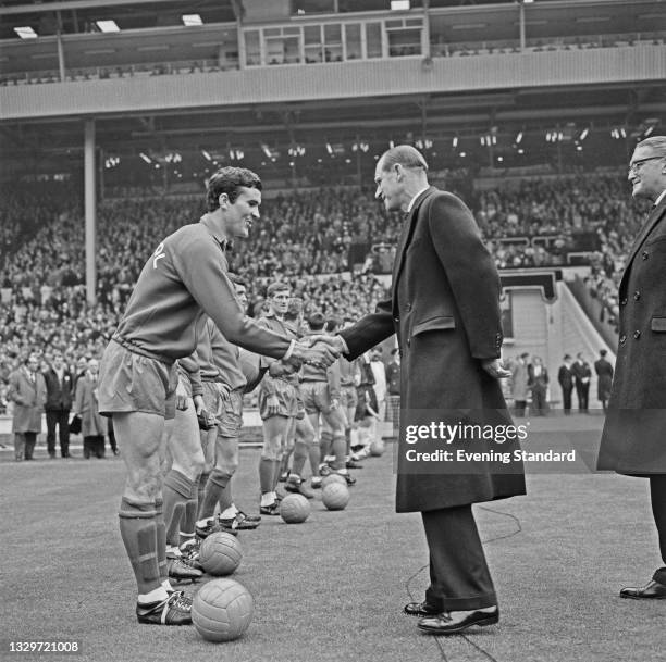 Prince Philip, the Duke of Edinburgh shakes hands with Ron Yeats, captain of Liverpool FC, during the 1965 FA Cup final at Wembley Stadium in London,...