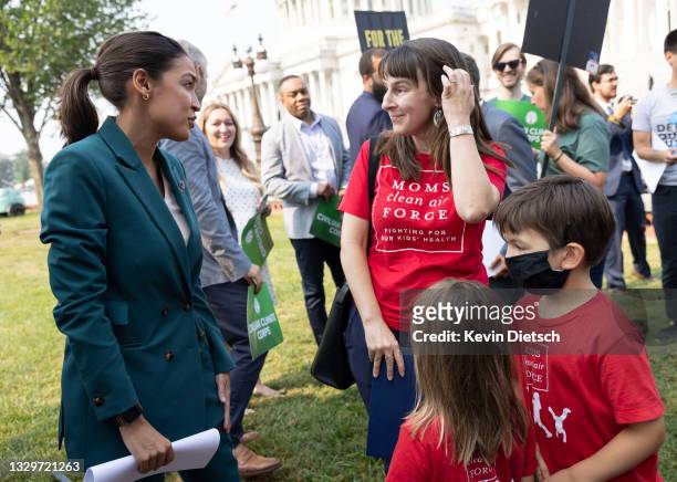 Rep. Alexandria Ocasio-Cortez greets Elizabeth Brandt, of Moms Clean Air Force, and her children Natalia and Valencia, after Ocasio-Cortez spoke at a...