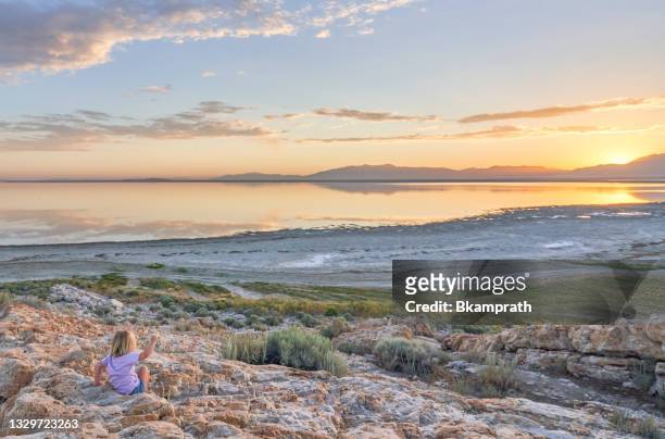 toddler girl enjoying the breathtaking sunrise in the beautiful 
antelope island state park near salt lake city, utah usa - salt lake city stock pictures, royalty-free photos & images